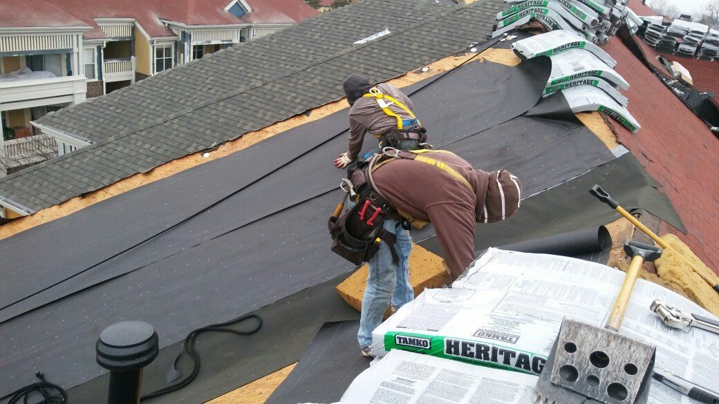 Two men are working on the roof of a building.