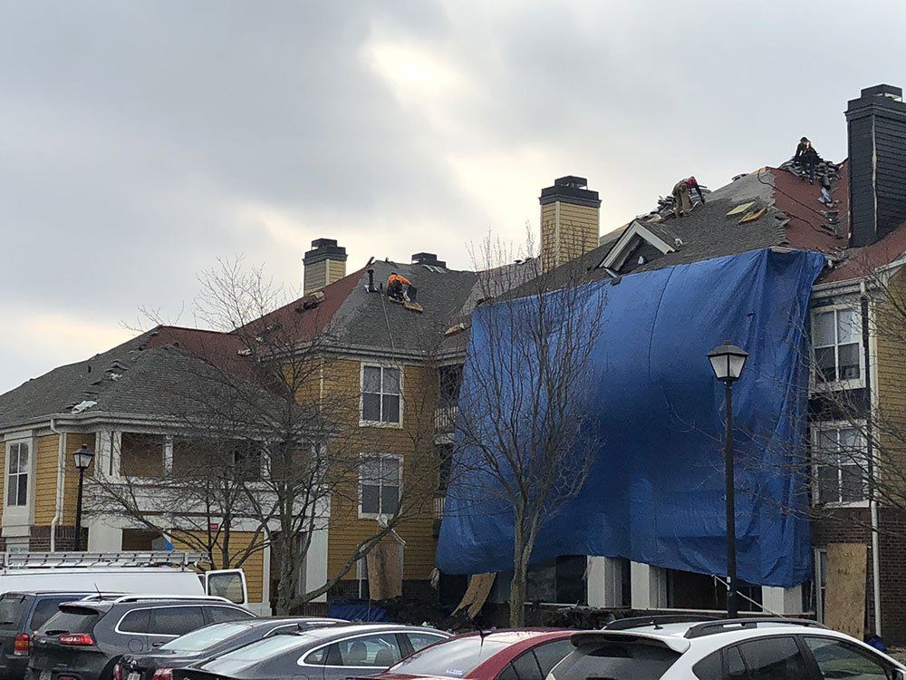 A blue tarp is covering the roof of a building.