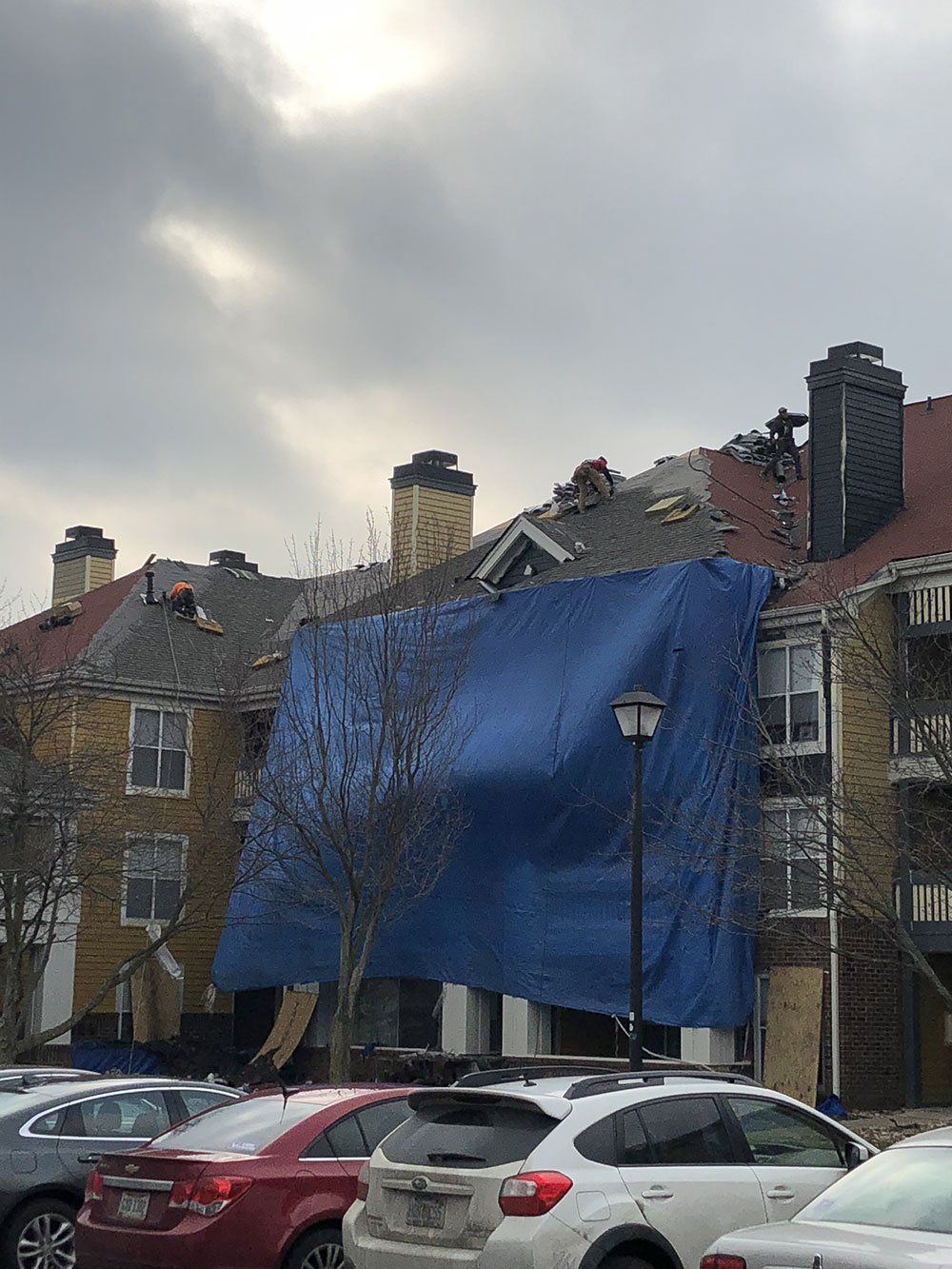 A blue tarp is covering the roof of a building.
