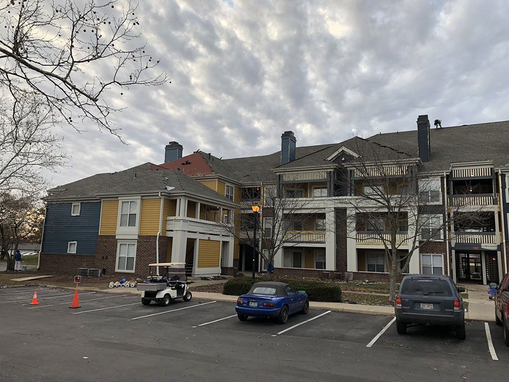 A large apartment building with cars parked in front of it.