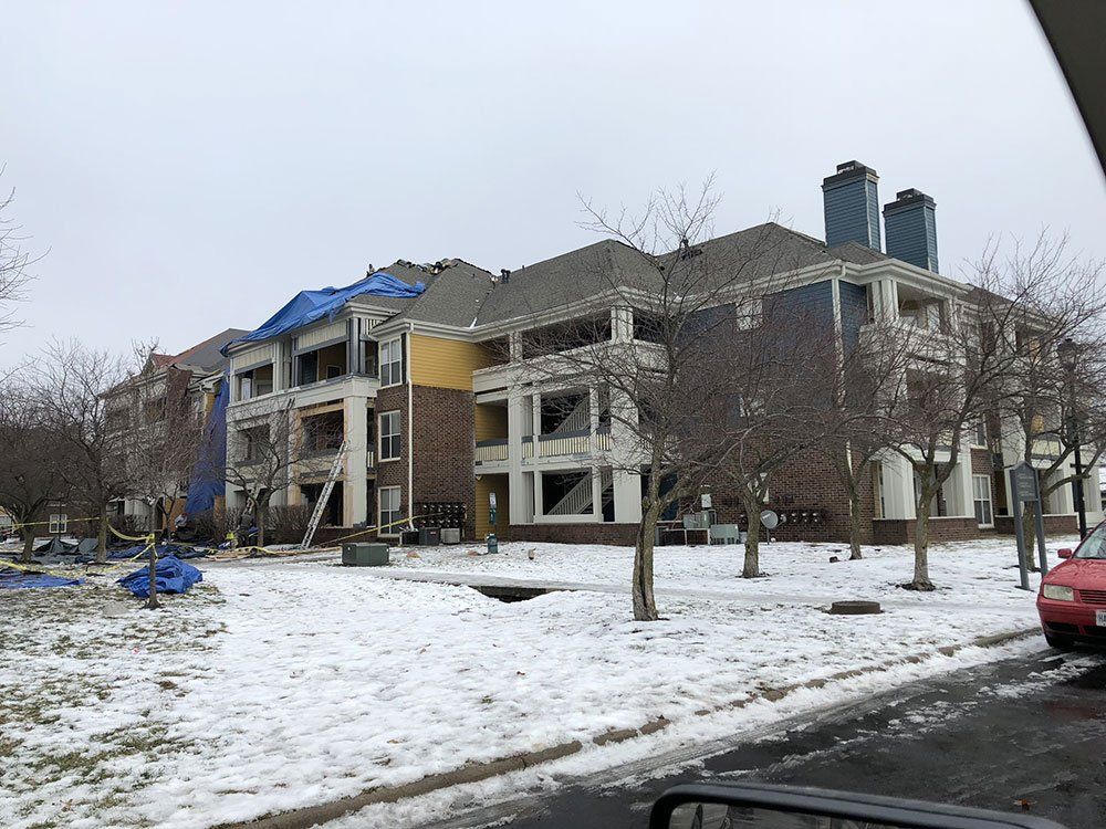 A large apartment building under construction in the snow.