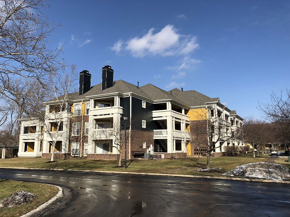 A large apartment building with a lot of windows and chimneys on a sunny day.