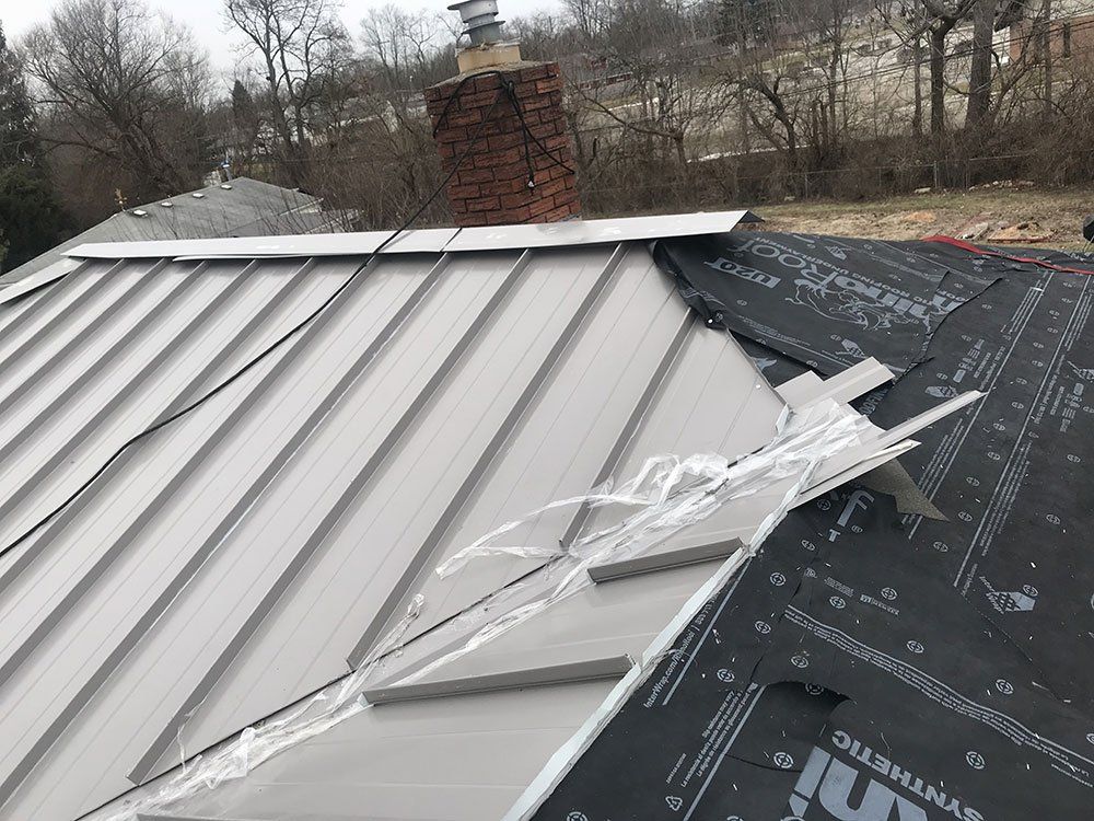 A metal roof is being installed on a house.