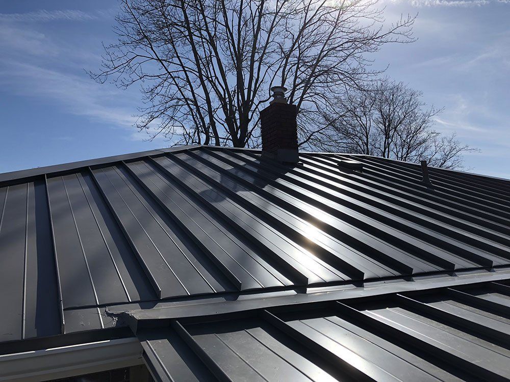 A metal roof with a chimney on top of it.