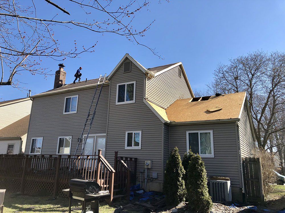 A man is working on the roof of a house.