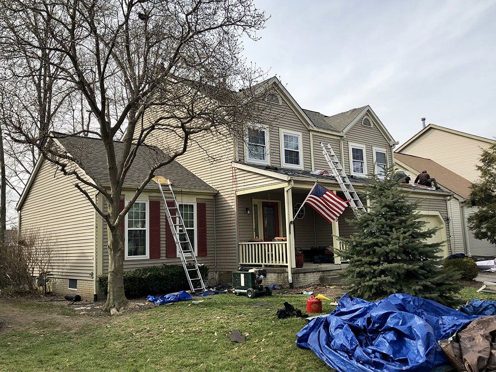 A house with a flag on the porch is being painted.