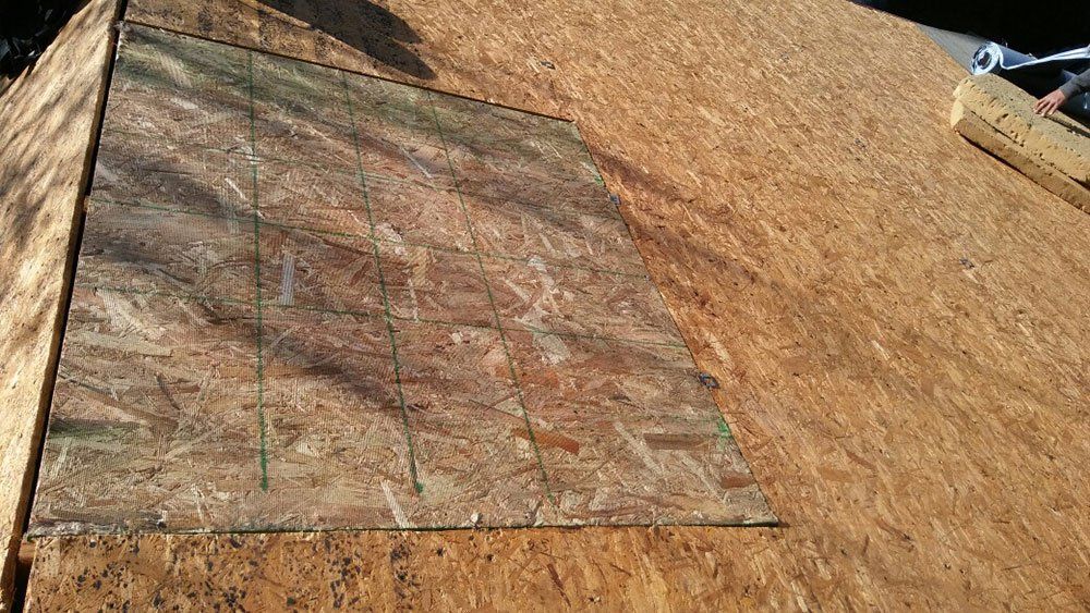 A piece of plywood is sitting on top of a wooden roof.
