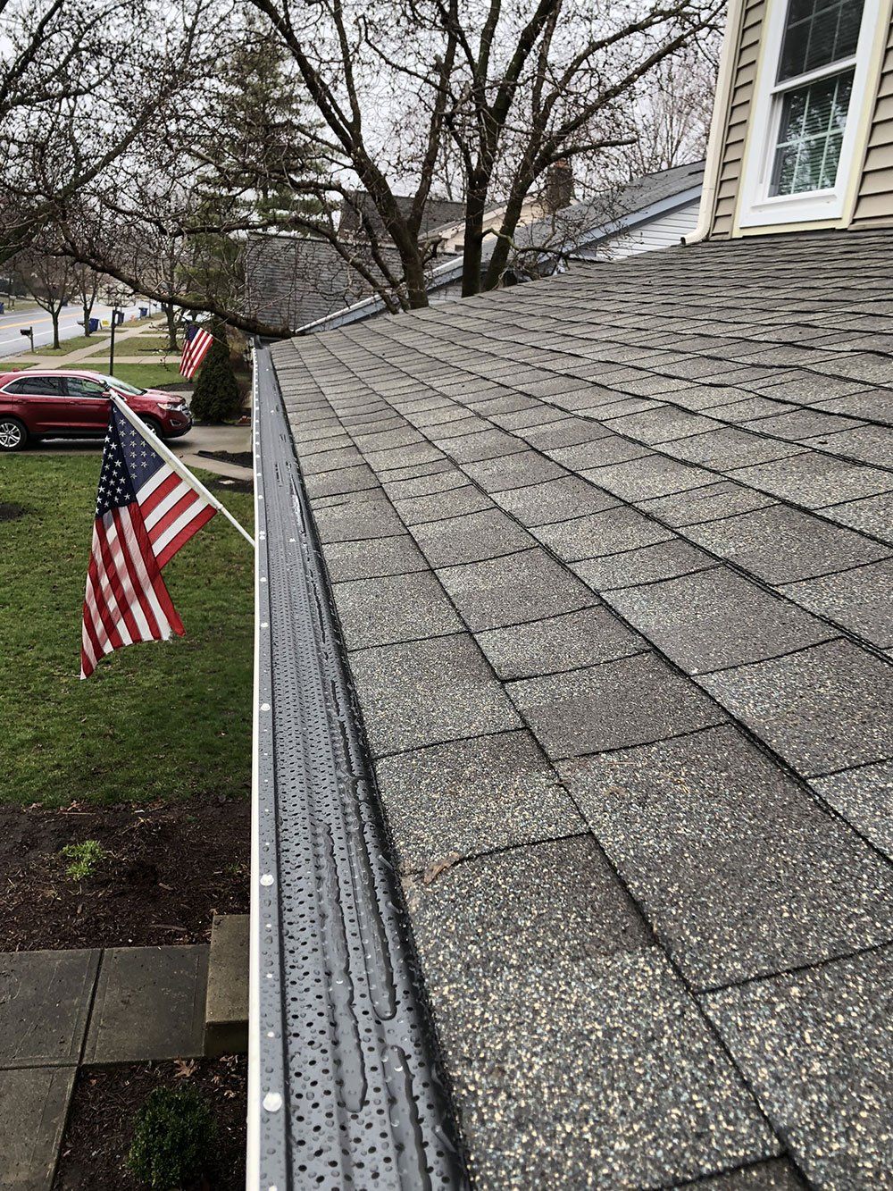 A house with a gutter and an american flag on the roof.