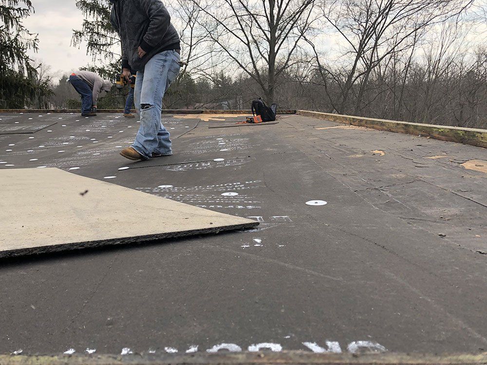 A group of men are working on a roof.