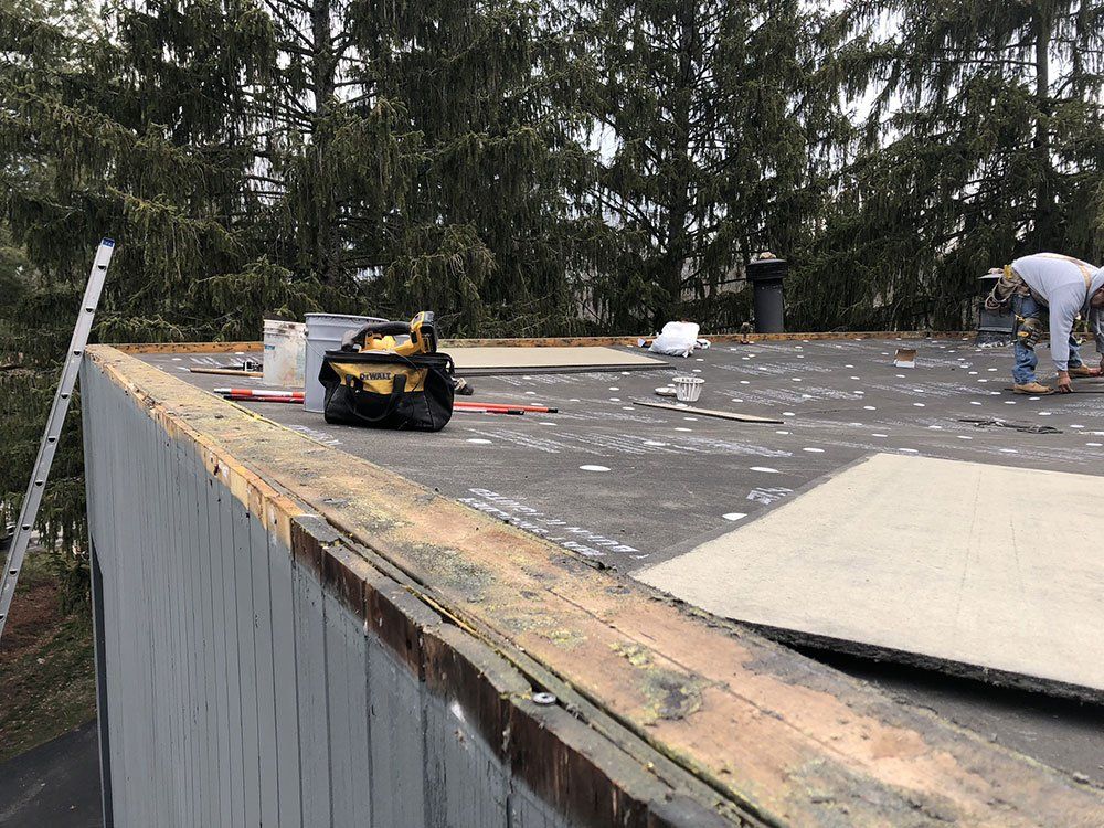 A man is working on the roof of a building.