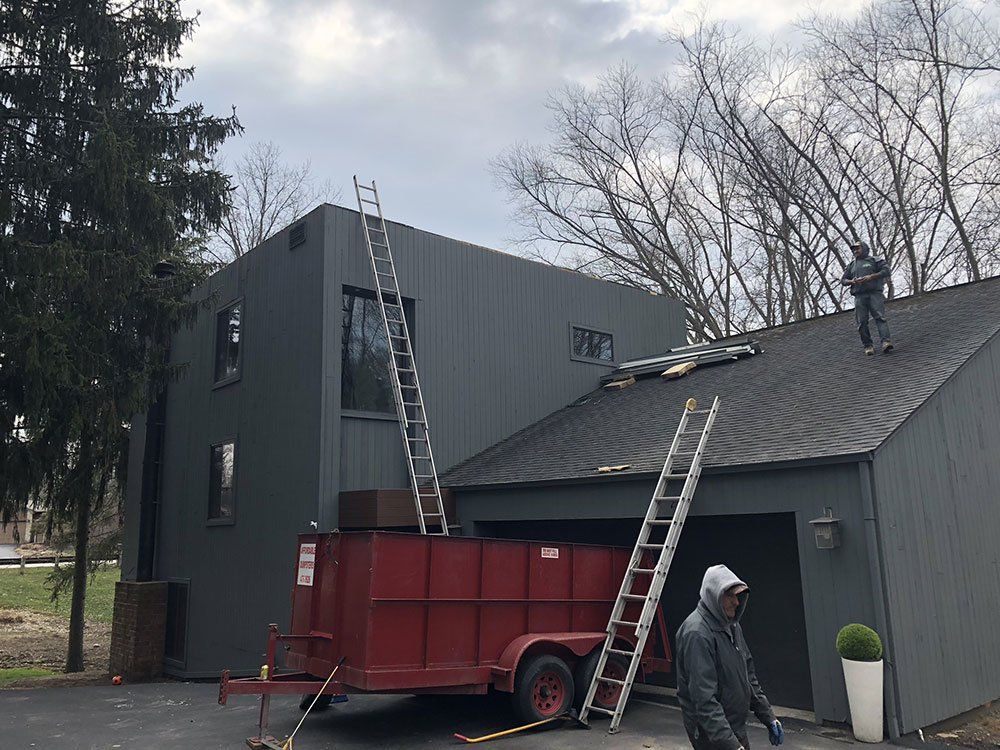 A man is working on the roof of a house.
