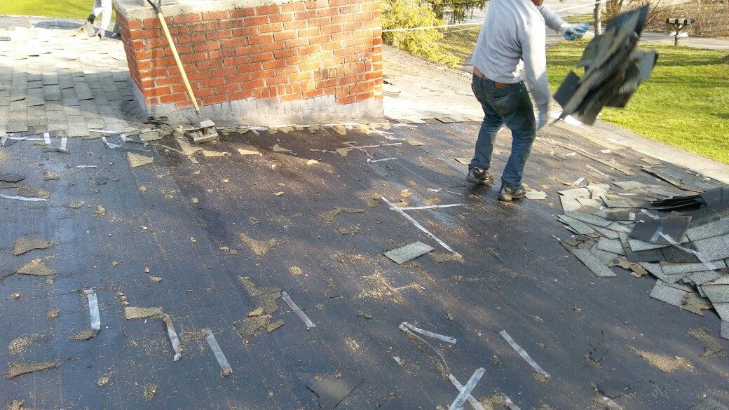 A man is removing a chimney from a roof.
