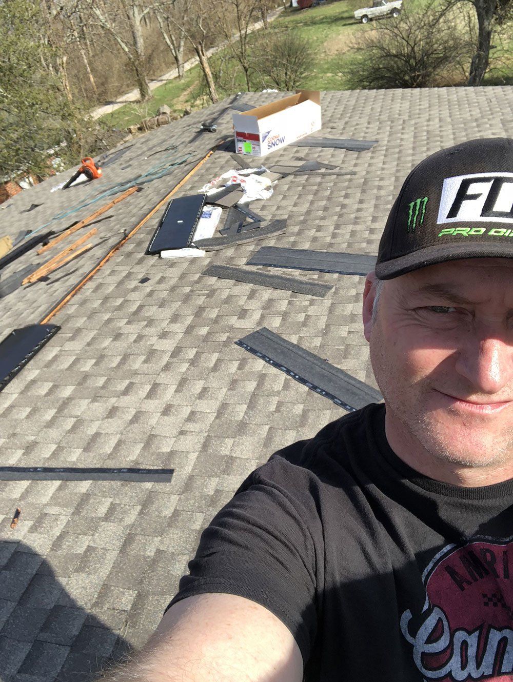 A man is taking a selfie on top of a roof.