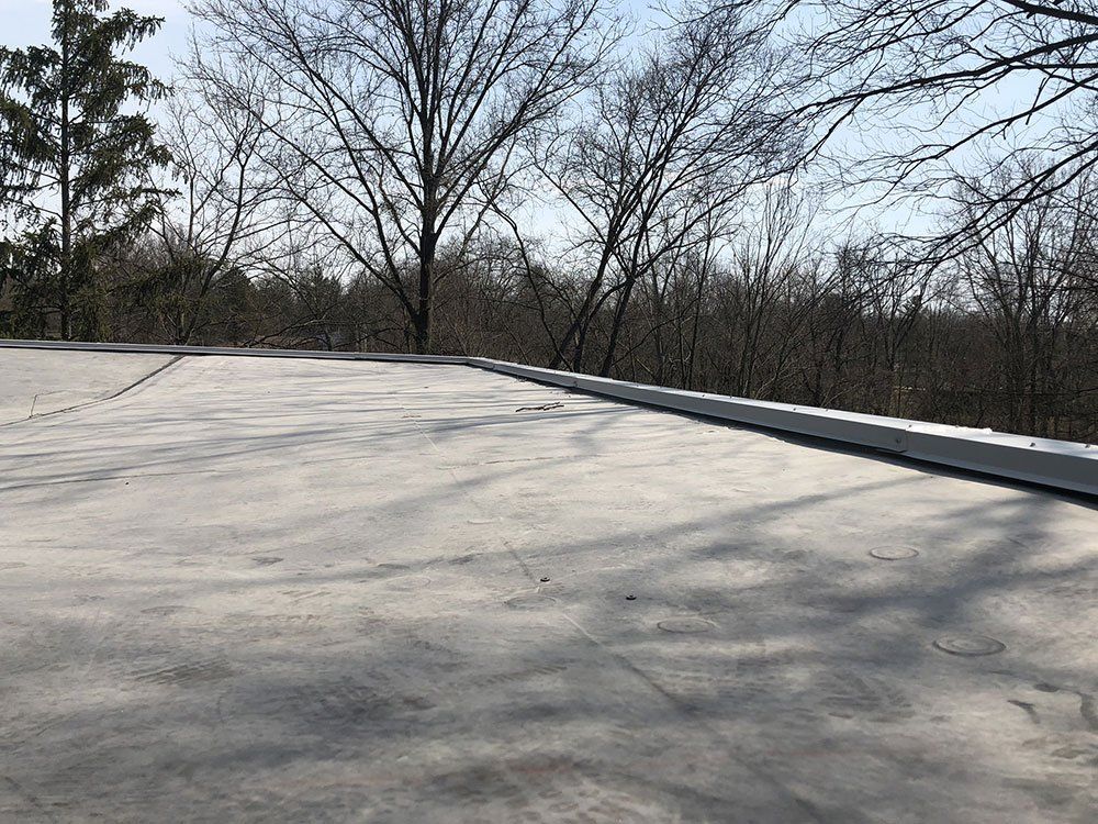A concrete roof with trees in the background.