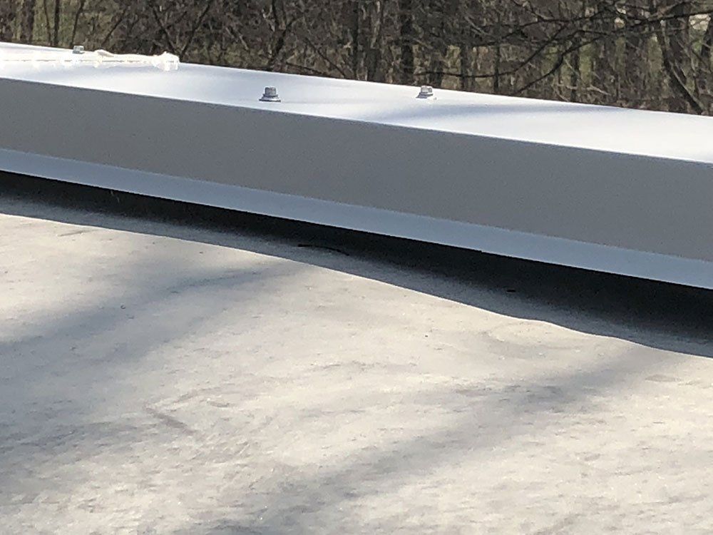 A white beam is sitting on top of a concrete surface.