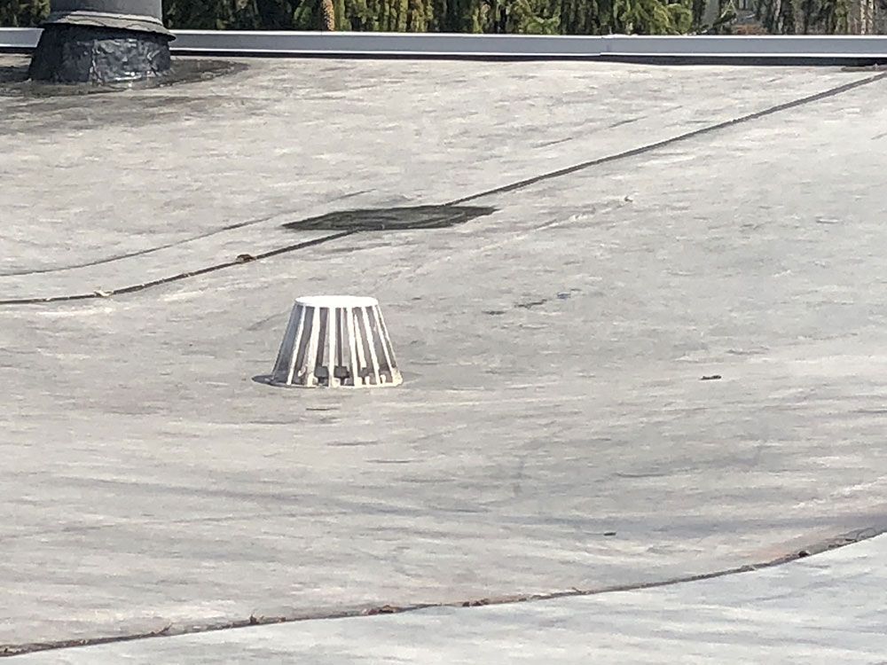 There is a drain on the roof of a building.