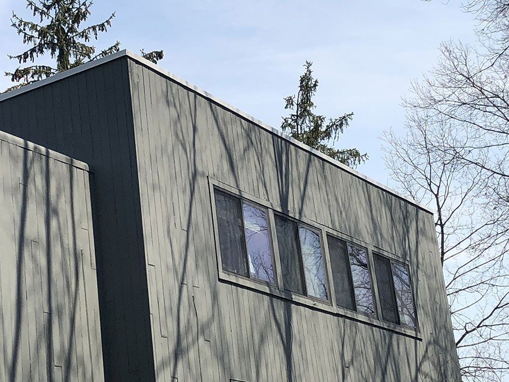 A large building with a lot of windows and trees in the background.