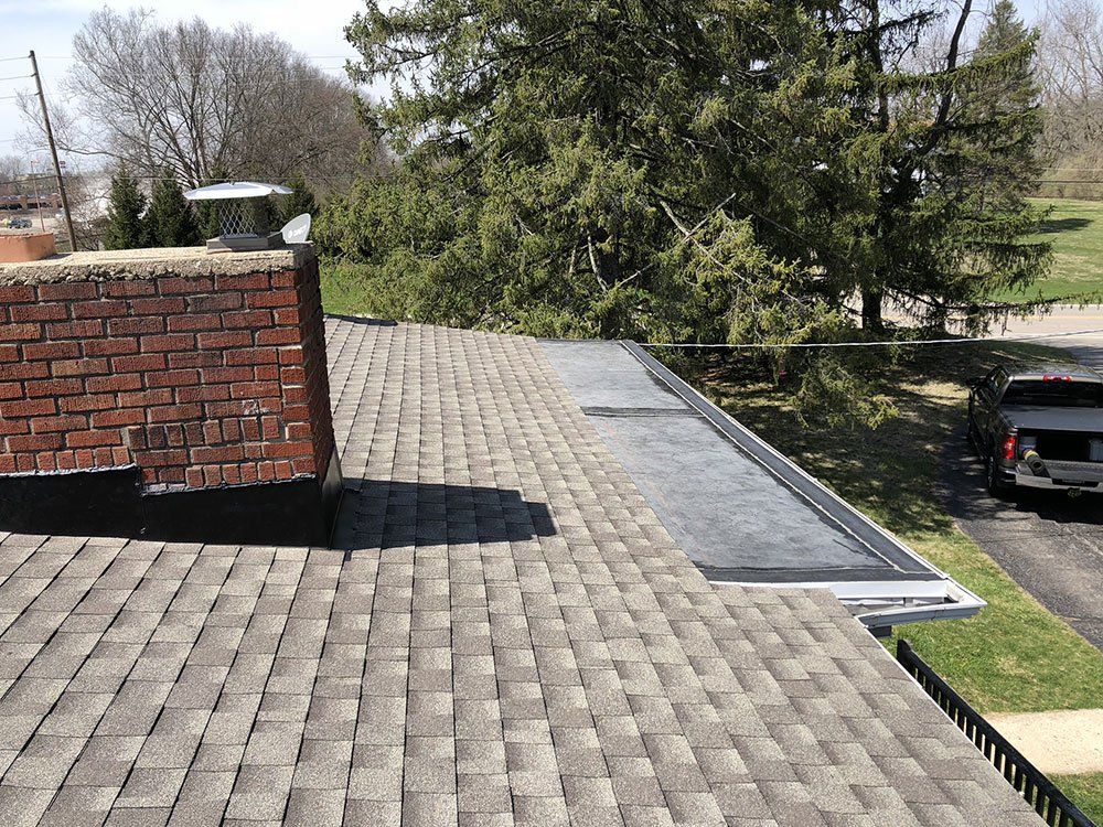 A roof with a brick chimney and a truck parked on it.