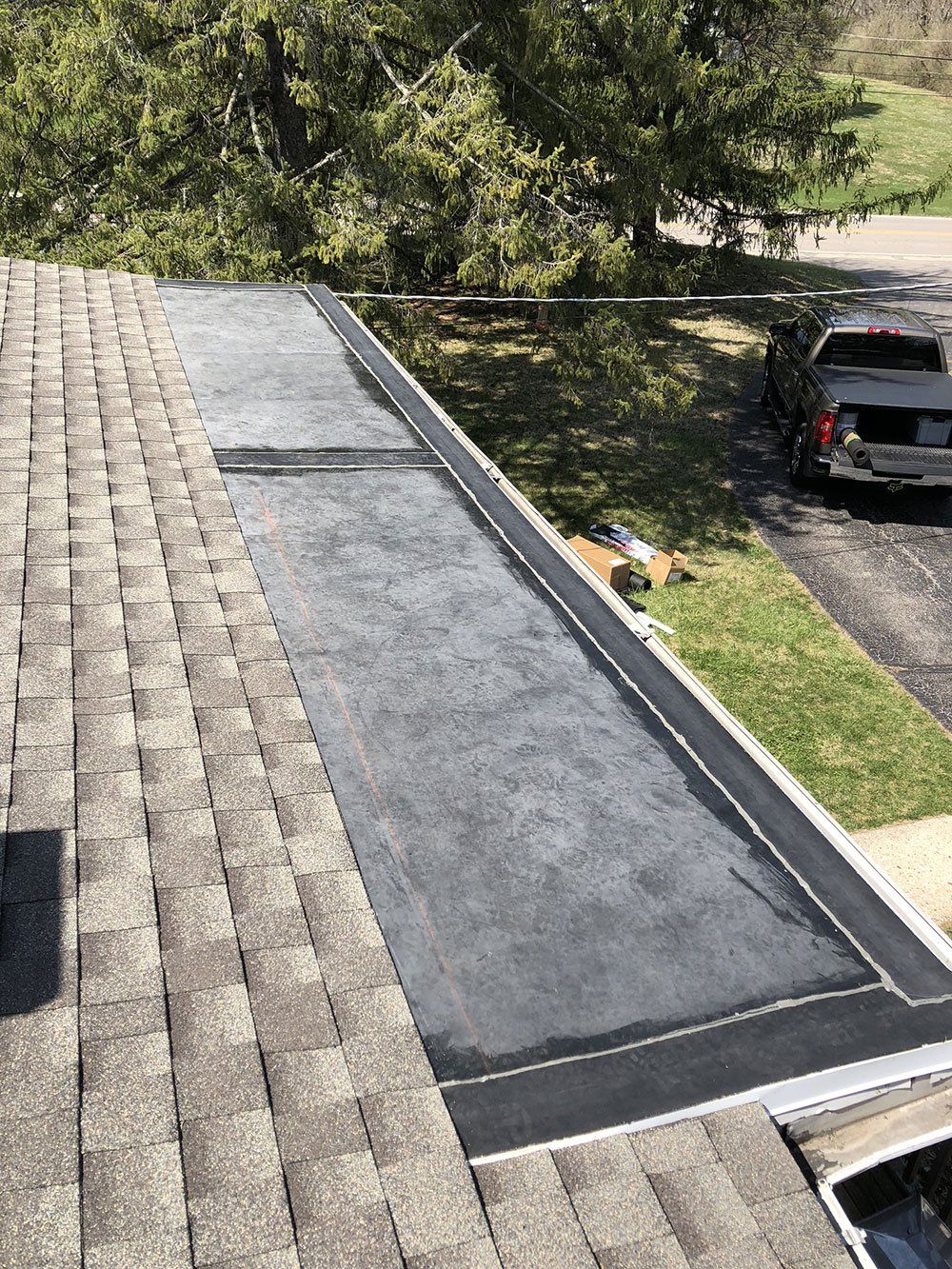 A car is parked on the side of the road next to a roof.