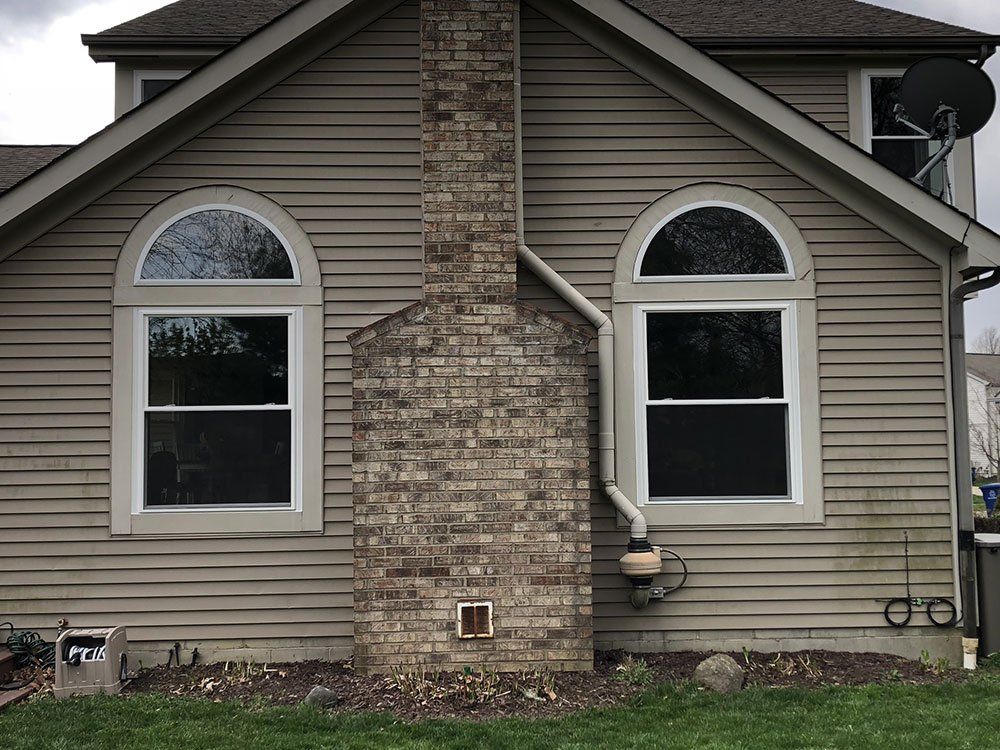 A house with arched windows and a brick chimney