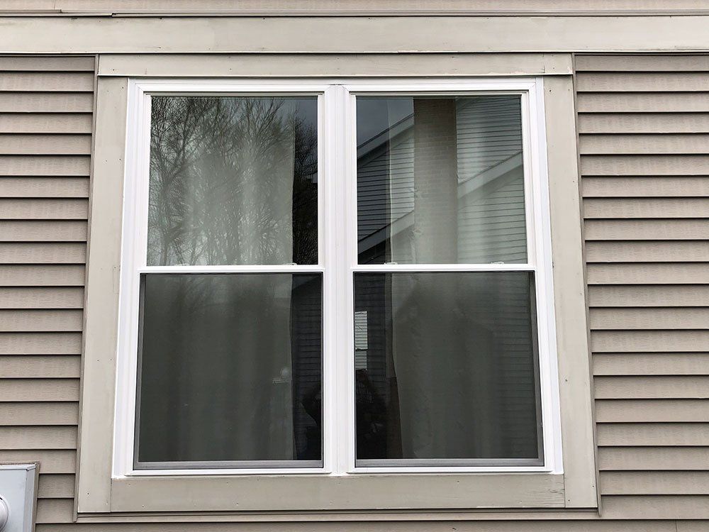 A window on the side of a house with a white frame.