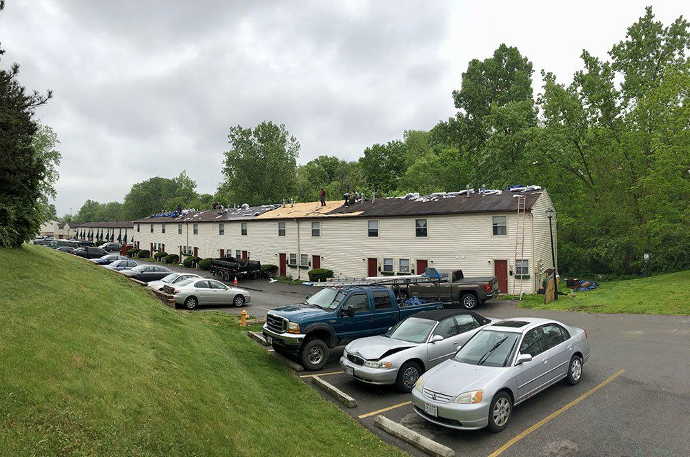 A row of cars are parked in front of a building.