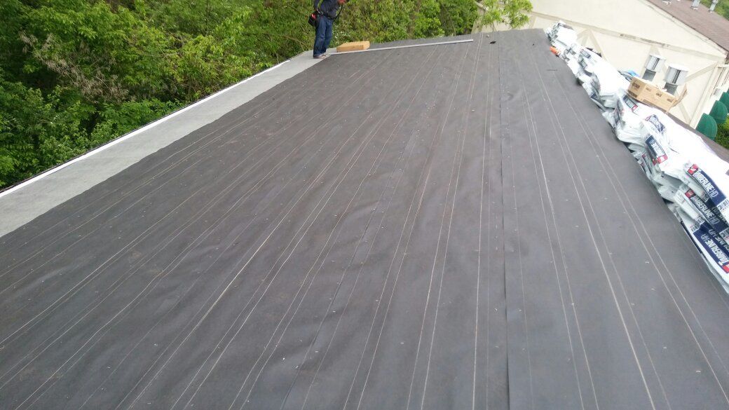 A man is standing on the roof of a house.