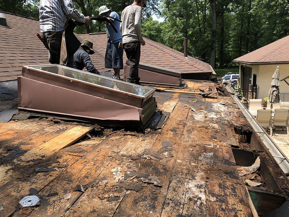 A group of people are working on the roof of a house.