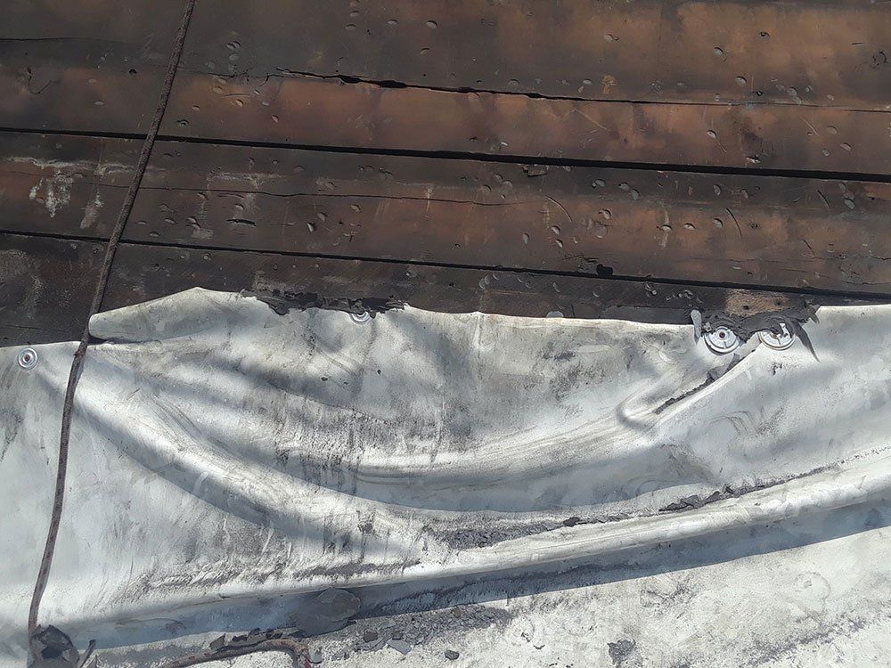A piece of metal is laying on top of a wooden floor.