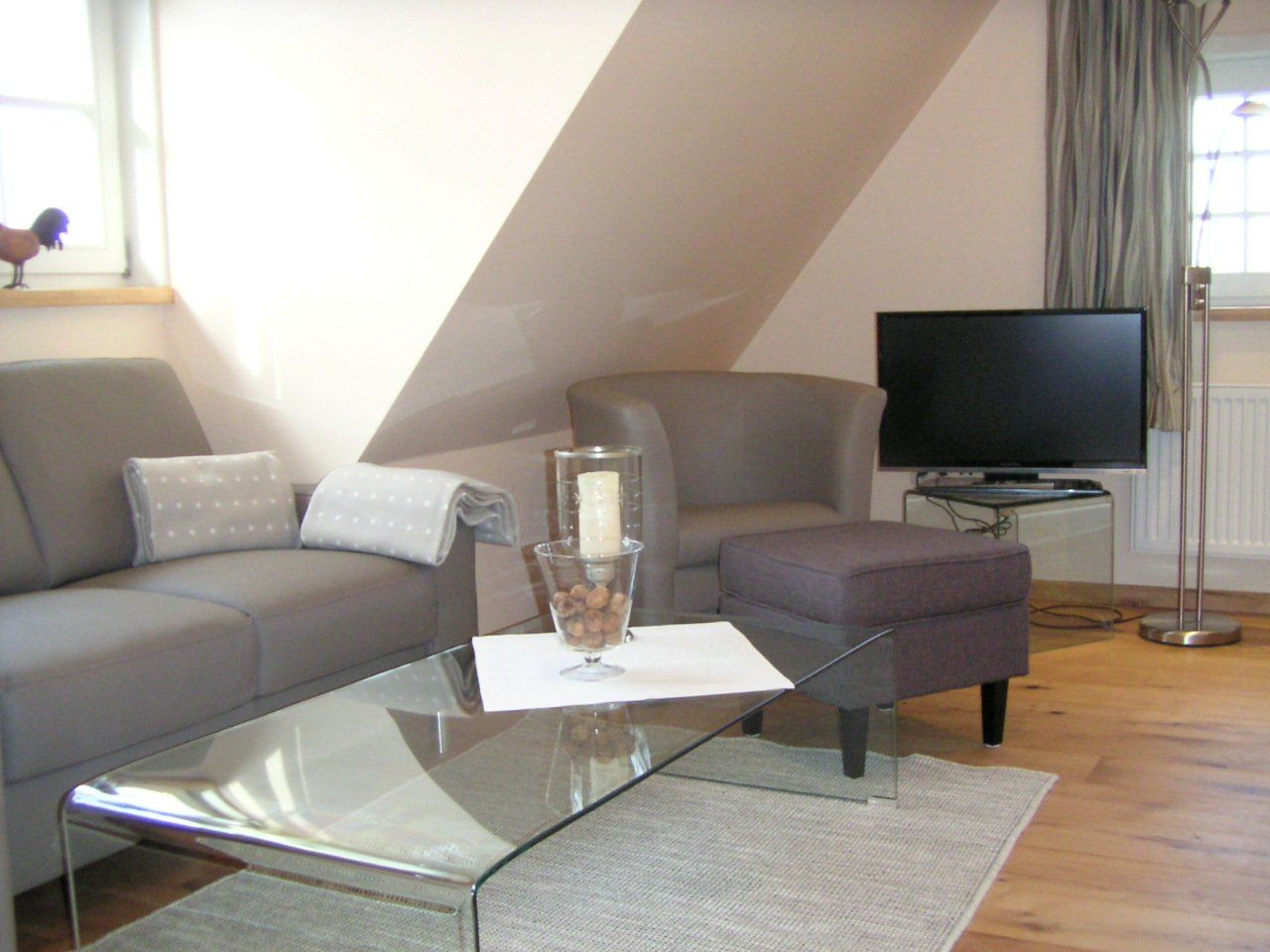 Een woonkamer met een bank, een stoel en een flatscreen-tv