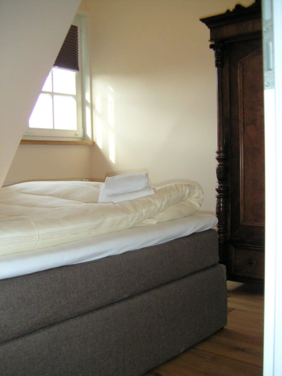 Ein Schlafzimmer mit einem Bett und einem Kleiderschrank und einem Fenster