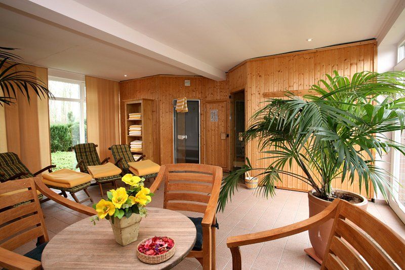 Een kamer met een tafel, stoelen en een plant