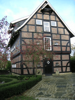 Een groot bakstenen gebouw met een zwart dak