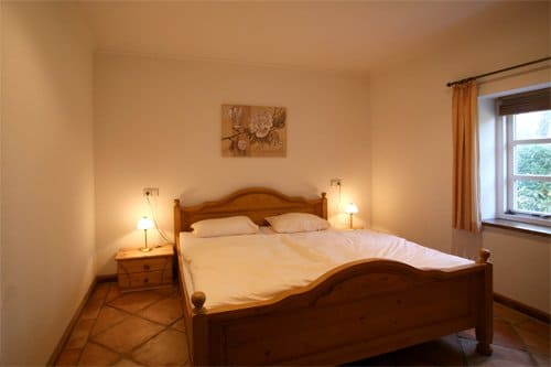 Ein Schlafzimmer mit Bett, Nachttisch und Fenster.