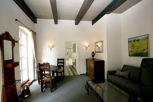 Een woonkamer met een bank, een tafel en stoelen