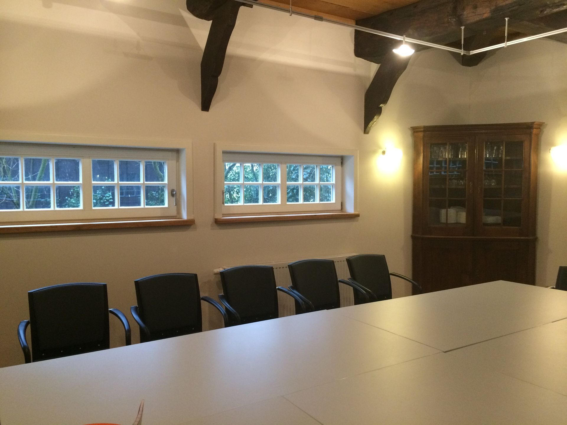 Een vergaderruimte met een lange tafel en stoelen
