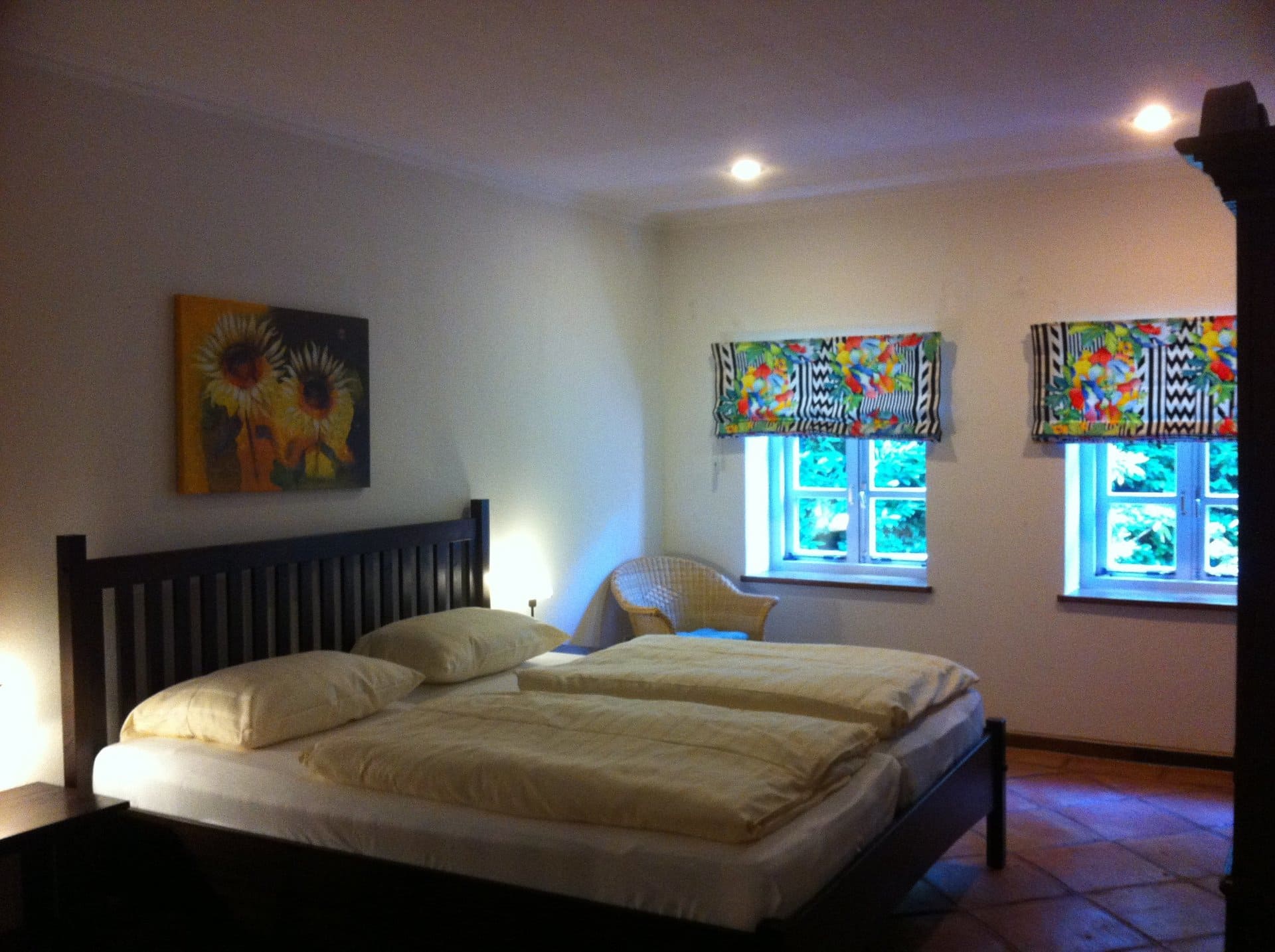Ein Schlafzimmer mit einem Gemälde einer Sonnenblume an der Wand über dem Bett