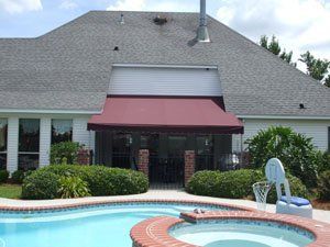Standing Seam Awnings — Red Awnings Installed In Front Of The House in Chalmette, LA Standing Seam Awnings — Red Awnings Installed In Front Of The House in Chalmette, LA