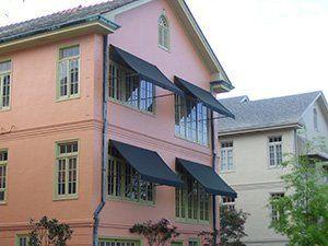 Awning Covers — Two Story House With Awning On The Windows in Chalmette, LA Awning Covers — Two Story House With Awning On The Windows in Chalmette, LA