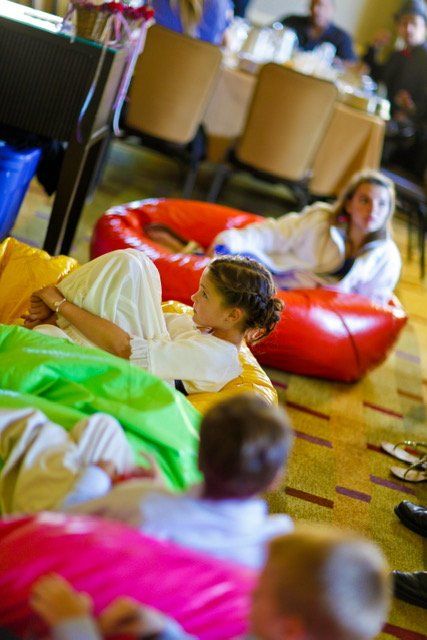 A group of children are laying on bean bags on the floor.
