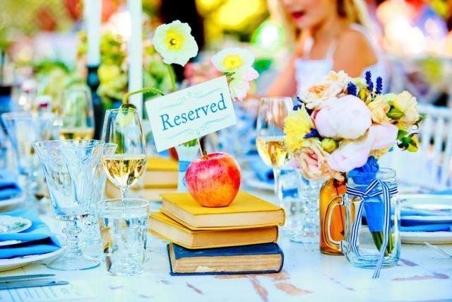 A reserved sign is sitting on top of a stack of books.
