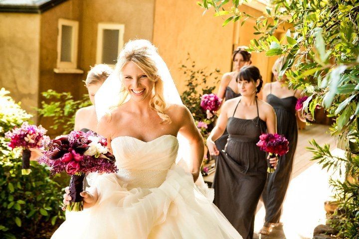 A bride and her bridesmaids are walking down a path