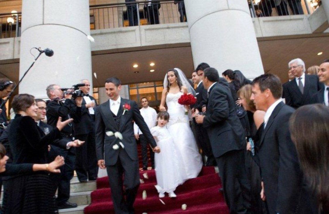 A bride and groom are walking down the stairs at their wedding