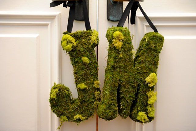 The letters j and m are made of moss and hanging on a door
