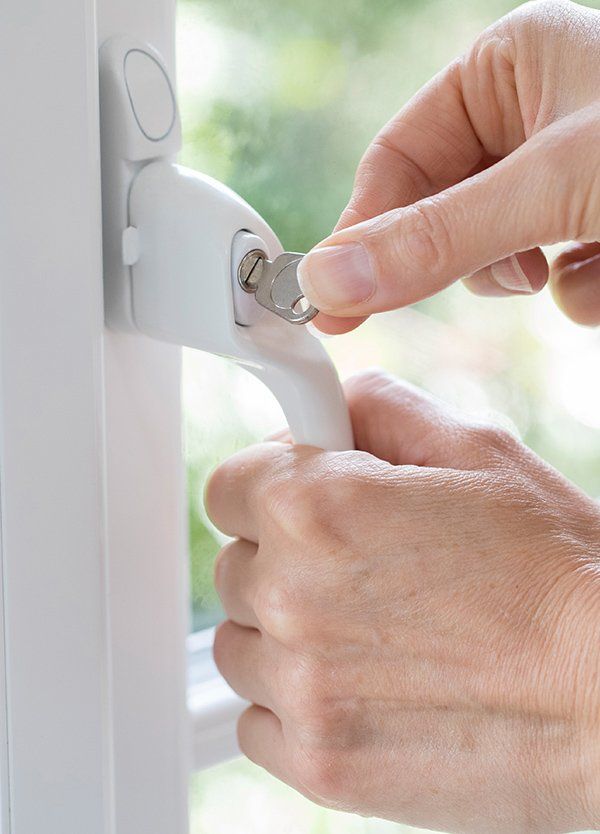 Woman Turning Key In Window Lock — Safe N Sound Locksmiths in Varsity Lakes, QLD