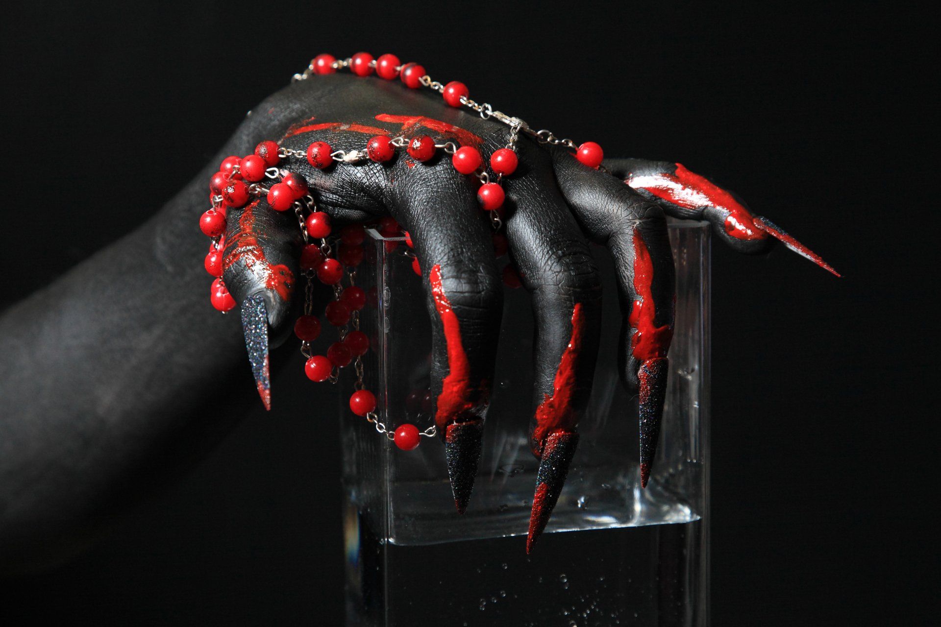 main noire avec bijouterie rouge