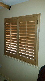 A window with wooden shutters on it in a room.