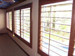 A hallway with a lot of windows and a ceiling fan.