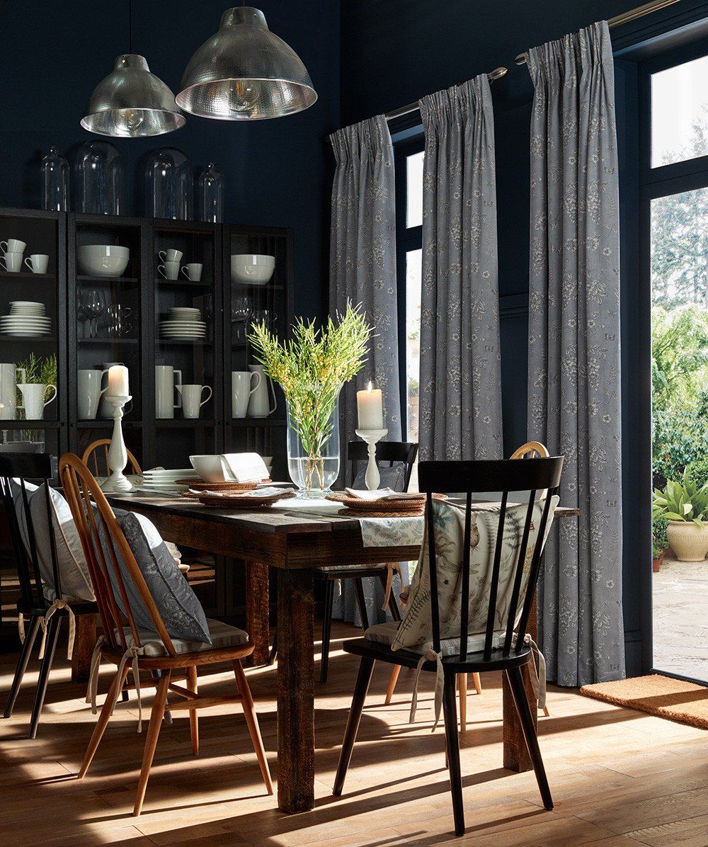 Stylish patterned curtains and wooden dining set