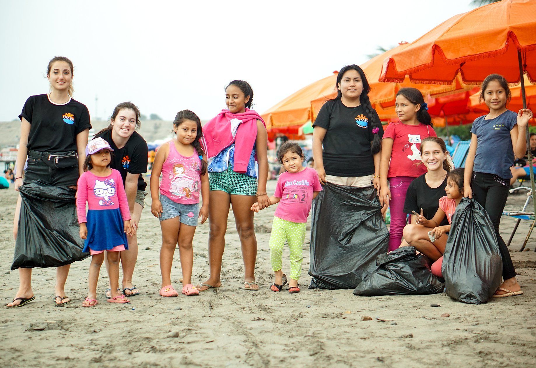 Otra Cosa volunteers and local children carrying out a beach clean in Huanchaco, Peru